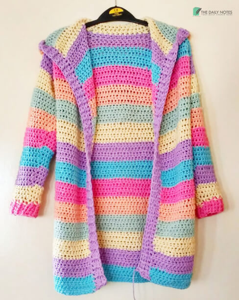 A Pink Halter Neck One Piece Swimsuit Paired With Rainbow Colored Crochet Jacket